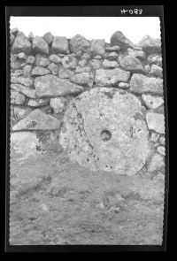 Grindstone set in a wall.