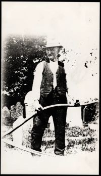 Will Gillard with scythe in churchyard, 1930