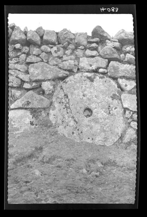 Grindstone set in a wall.