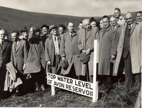 At the start of work on the Avon Dam, officials stand around the planned top water level marker 