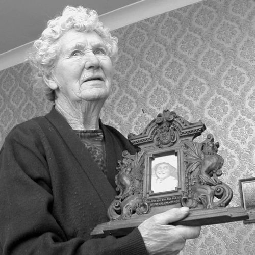 Margaret Burgoyne aged 92 holding photographs of herself aged 5